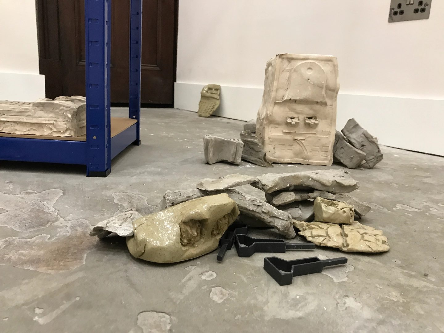 Glazed ceramic, unfired clay, 3D printed SLS plastic, shelving, found objects, plaster